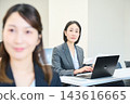 一位年輕的辦公室職員正在辦公室與團隊成員一起查看文件。 143616665