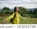 A female hiker takes a deep breath in a hilly area. 143616784