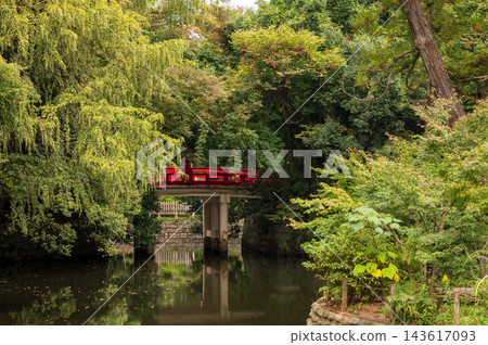 日式花園中一座朱紅色的橋,四周綠樹環繞。 日式花園中一座朱紅色的橋,四周綠樹環繞。 143617093