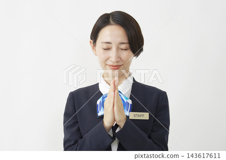 A middle-aged female staff member praying against a white background. A middle-aged female staff member praying against a white background. 143617611