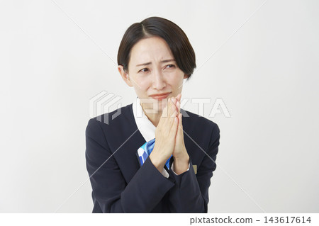 A middle-aged female staff member praying against a white background. A middle-aged female staff member praying against a white background. 143617614