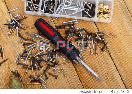 Screwdriver and screws on wooden table 143617890