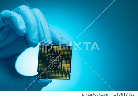 Electronic engineer holding CPU processor chip against blue background in a technology laboratory, close up semiconductor hardware for computer repair, system upgrade, research and digital innovation 143618432