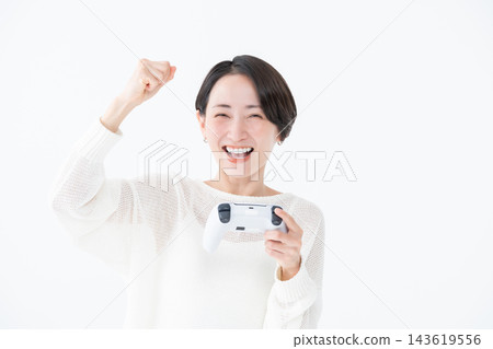 一名女子正在玩遊戲,並擺出勝利姿勢。 一名女子正在玩遊戲,並擺出勝利姿勢。 143619556