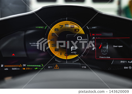 Ferrari Purosangue cluster shows yellow tachometer, hybrid status, wet mode, 0 kmh, gear P auto, door open alert, battery bars, 5220 km, crisp studio lighting. 143620009