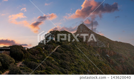 Cape Point in Table Mountain National Park, near Cape Town, shows a lighthouse and tall masts on a rocky summit, zigzag footpaths, fynbos, and sea cliffs at sunset. Cape Point in Table Mountain National Park, near Cape Town, shows a lighthouse and tall masts on a rocky summit, zigzag footpaths, fynbos, and sea cliffs at sunset. 143620040