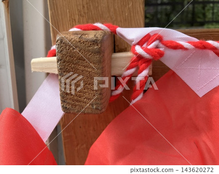 Wedges driven into the wooden framework and red and white ropes Wedges driven into the wooden framework and red and white ropes 143620272