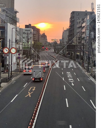 從高架橋上望去,城市街道和城市景觀沐浴在夕陽之中。 從高架橋上望去,城市街道和城市景觀沐浴在夕陽之中。 143621581