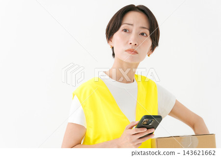 女送貨員抱著一個紙箱 女送貨員抱著一個紙箱 143621662