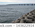 Concrete Tetrapod Breakwater Shoreline with Kansai International Airport Sky Gate Bridge in Osaka, Japan. 143622914