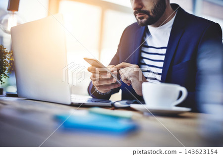 Laptop, coffee and businessman with phone in cafe for online email communication for corporate review. Freelancer, cappuccino and hr with computer and cellphone for company policy with remote work. Laptop, coffee and businessman with phone in cafe for online email communication for corporate review. Freelancer, cappuccino and hr with computer and cellphone for company policy with remote work. 143623154