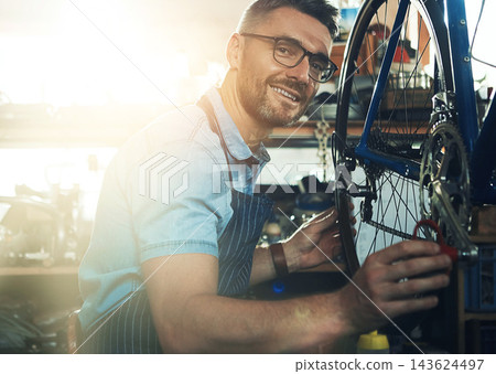 Man, garage and happy as bicycle mechanic with lens flare in startup or small business. Workshop, portrait and smile or confident as handyman with fixing bike at repair or maintenance shop Man, garage and happy as bicycle mechanic with lens flare in startup or small business. Workshop, portrait and smile or confident as handyman with fixing bike at repair or maintenance shop 143624497
