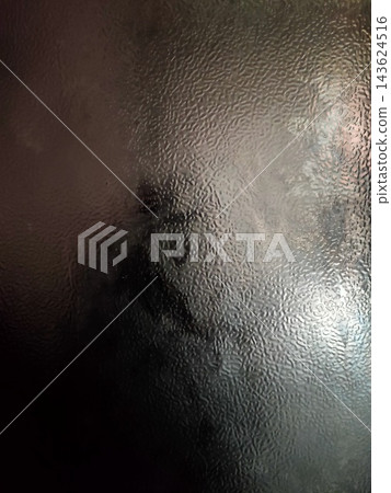 A shadowy figure blurs behind textured glass, creating a mysterious and softly lit visual effect. A shadowy figure blurs behind textured glass, creating a mysterious and softly lit visual effect. 143624516