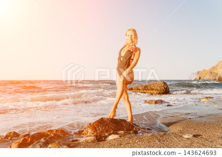 Mature woman posing on ocean rocks during sunset lifestyle photography session Mature woman posing on ocean rocks during sunset lifestyle photography session 143624693
