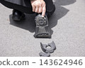 一名男子正在檢查鞋子破損的鞋跟。 143624946