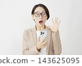 A middle-aged businesswoman looks surprised while looking at her smartphone against a white background. 143625095