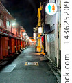 A lit alley at night, an old Japanese shopping street stretching into the distance. 143625209