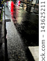 The reflection of red neon lights stretches across the wet roads at night in Japan. 143625211