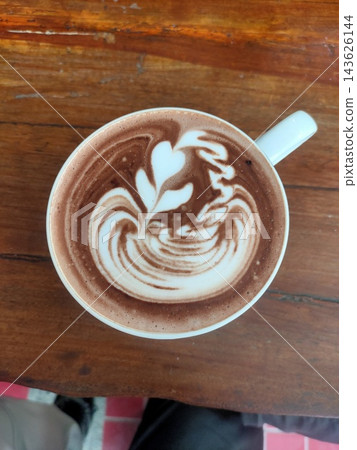 Cup of hot chocolate with latte art on a wooden table Cup of hot chocolate with latte art on a wooden table 143626144