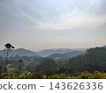 Scenic hazy green hills and village 143626336