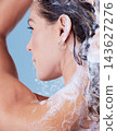 Woman, washing hair and shampoo foam in studio, cleaning and haircare in shower on blue background. Female person, profile and bubble soap for cosmetics, treatment and grooming scalp under water 143627276