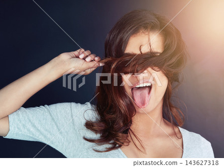 Woman, hair and hiding on studio background for beauty, cosmetics and healthy growth or textures. Female person, tongue out and humor for haircare, keratin treatment and comedy for dermatology curls 143627318