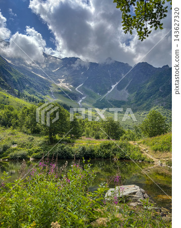 Alpine valley with lake and flowers in Les Contamines-Montjoie, France Alpine valley with lake and flowers in Les Contamines-Montjoie, France 143627320