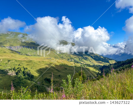 Cloudy mountain slopes above alpine meadows in Les Contamines-Montjoie, France 143627322