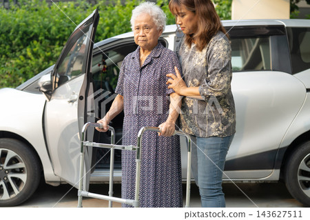 Caregiver help Asian elderly woman disability patient get in her car. Caregiver help Asian elderly woman disability patient get in her car. 143627511