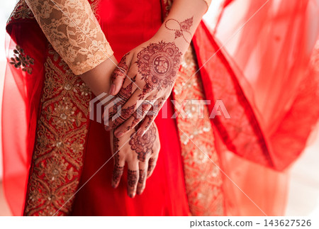 Indian bride, hands and mehendi for wedding, celebration and love for marriage. Woman, henna and culture with traditional temporary tattoo, sari and hindu bridal jewelry with bangles and red veil 143627526