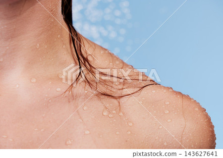 Woman, cleanse and shower for shoulder in studio, washing and grooming for skincare on blue background. Female person, water and liquid for cosmetics or treatment and hydration, beauty and skin 143627641