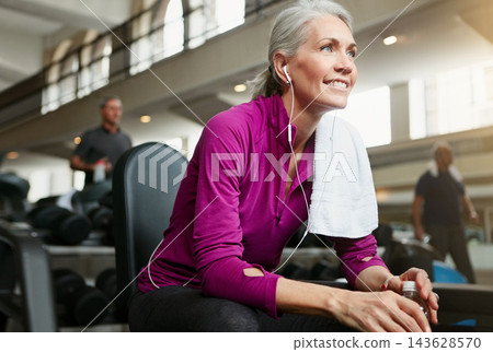 Woman, earphones and break from training in gym, fitness and relax after weight lifting or exercise. Mature person, towel and sound for progress at health club, sports and streaming online to rest 143628570