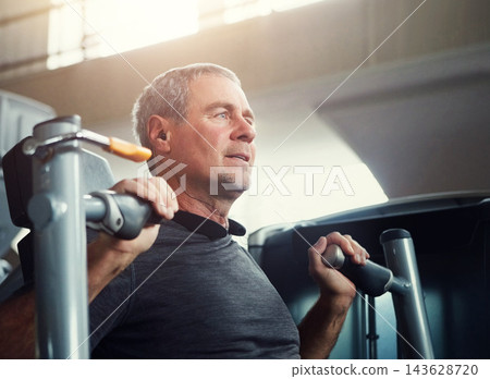 Mature man, weight machine and fitness in gym with vision for health, transformation and muscle development. Person, strength training and exercise with challenge for performance, workout or wellness 143628720
