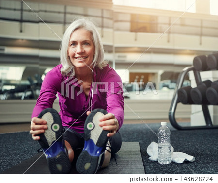 Shoes, fitness and portrait of mature woman stretching on gym floor for wellness, training and body warm up routine. Feet, face and female athlete with flexibility, practice and resting after workout 143628724