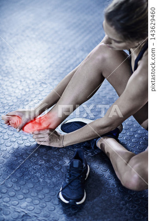 Woman, fitness and foot injury with red glow for accident, bruise or pain in workout or exercise on gym floor. Closeup of female person with sore feet, ache or bone from inflammation for hurt joint Woman, fitness and foot injury with red glow for accident, bruise or pain in workout or exercise on gym floor. Closeup of female person with sore feet, ache or bone from inflammation for hurt joint 143629460