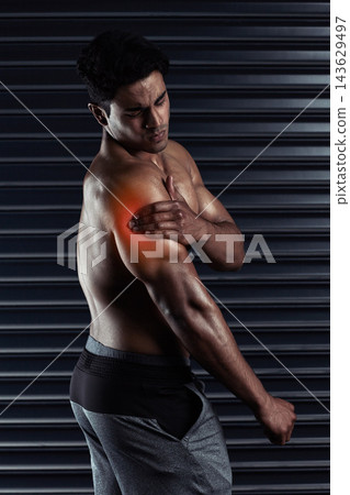 Shoulder pain, athlete or man with injury, red glow or body ache in fitness training or workout. Dark background, sore triceps muscles or sports person with bruised arm in accident, gym or emergency 143629497