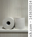 Toilet paper lined up on a wooden shelf 143630014