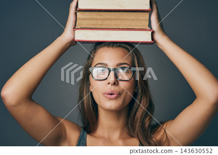 Woman, head and balance books in studio for learning, education or studying isolated on background. Student, university or thinking of research with textbook for knowledge, information or scholarship 143630552