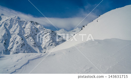 Mount Elbrus snow-covered ridge and distant Caucasus peaks under clear blue sky, pristine alpine powder slope in foreground Mount Elbrus snow-covered ridge and distant Caucasus peaks under clear blue sky, pristine alpine powder slope in foreground 143631715