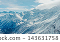 Snow-covered Caucasus mountain range with rugged peaks, deep valleys, and crisp winter daylight illuminating textured slopes and r 143631758