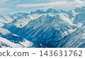 Snow-covered Caucasus mountain range with multiple peaks and deep valley under soft daylight sky 143631762