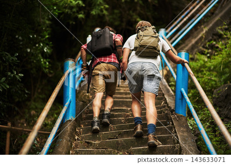Hiking, fitness and men on stairs on mountain for travel, adventure or exploring in nature. Backpack, outdoor and people trekking on steps, trail or path for exercise with walking on weekend trip. Hiking, fitness and men on stairs on mountain for travel, adventure or exploring in nature. Backpack, outdoor and people trekking on steps, trail or path for exercise with walking on weekend trip. 143633071