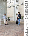 Diverse male travelers standing under modern canopy with rolling suitcases and checking smartphones 143634928