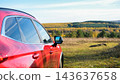 Red car side view parked in nature during autumn road trip, modern crossover vehicle with scenic forest background. Travel and adventure concept 143637658