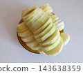 Sliced raw zucchini and courgette rounds piled high on a brown plate, preparing healthy fresh vegetable ingredients for cooking a delicious meal 143638359