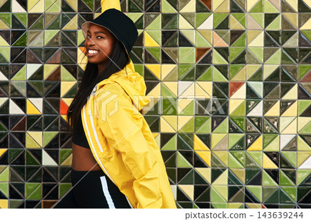 Black woman, portrait and jacket in city for fashion, stylish and wall background. Streetwear, trendy outfit and person in urban town for outdoors for holiday, influencer and bucket hat for summer Black woman, portrait and jacket in city for fashion, stylish and wall background. Streetwear, trendy outfit and person in urban town for outdoors for holiday, influencer and bucket hat for summer 143639244