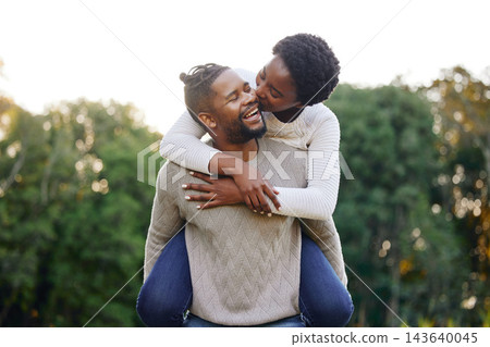 Piggyback, kiss and happy black couple at park for anniversary date or honeymoon romance with smile. Wellness, hug and African people in nature with support, care and love on holiday fun in garden 143640045