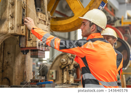 Male manufacturing in high visibility jacket and hard hat operator managing machine. 143640576
