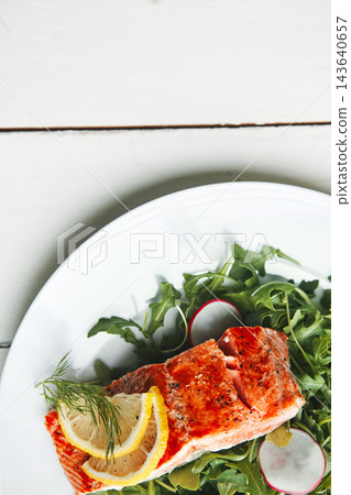 Plate, food or fish with lemon, above and salad for health, wellness and nutrition to lose weight in home. Salmon, dinner or lunch with fruit, leaves and vegetables for diet, seafood and healthy meal Plate, food or fish with lemon, above and salad for health, wellness and nutrition to lose weight in home. Salmon, dinner or lunch with fruit, leaves and vegetables for diet, seafood and healthy meal 143640657