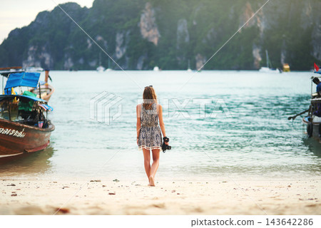 Back, woman and camera for beach travel in Maldives for vacation, holiday and photography by boats. Female photographer, ocean and shoreline in nature for tourism and trip, paradise for memories 143642286